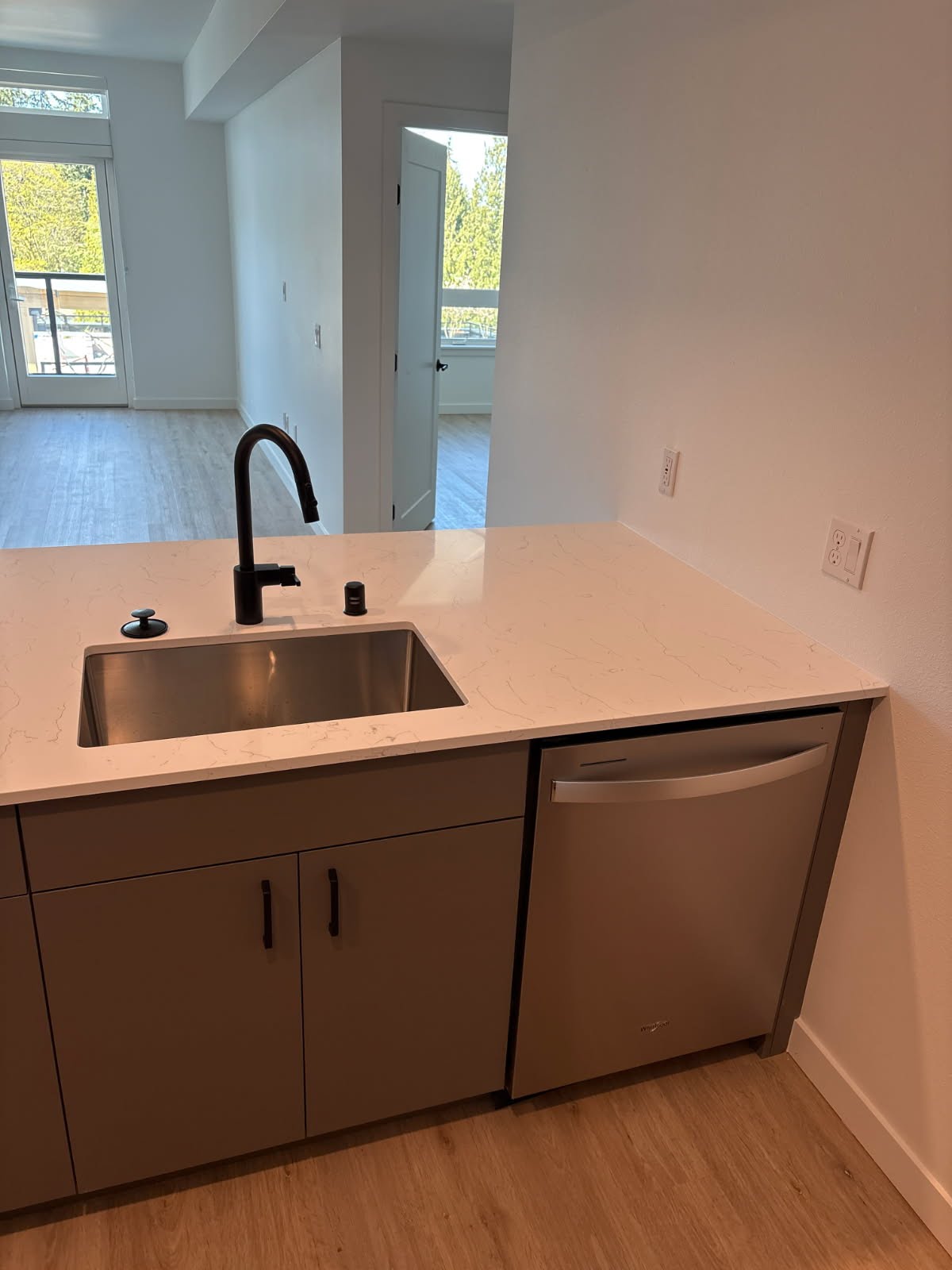 Kitchen remodel on Camano Island — undermount stainless sink, quartz counter, matte black pull-down faucet, stainless dishwasher